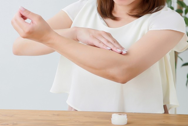 腕にクリームを塗る女性